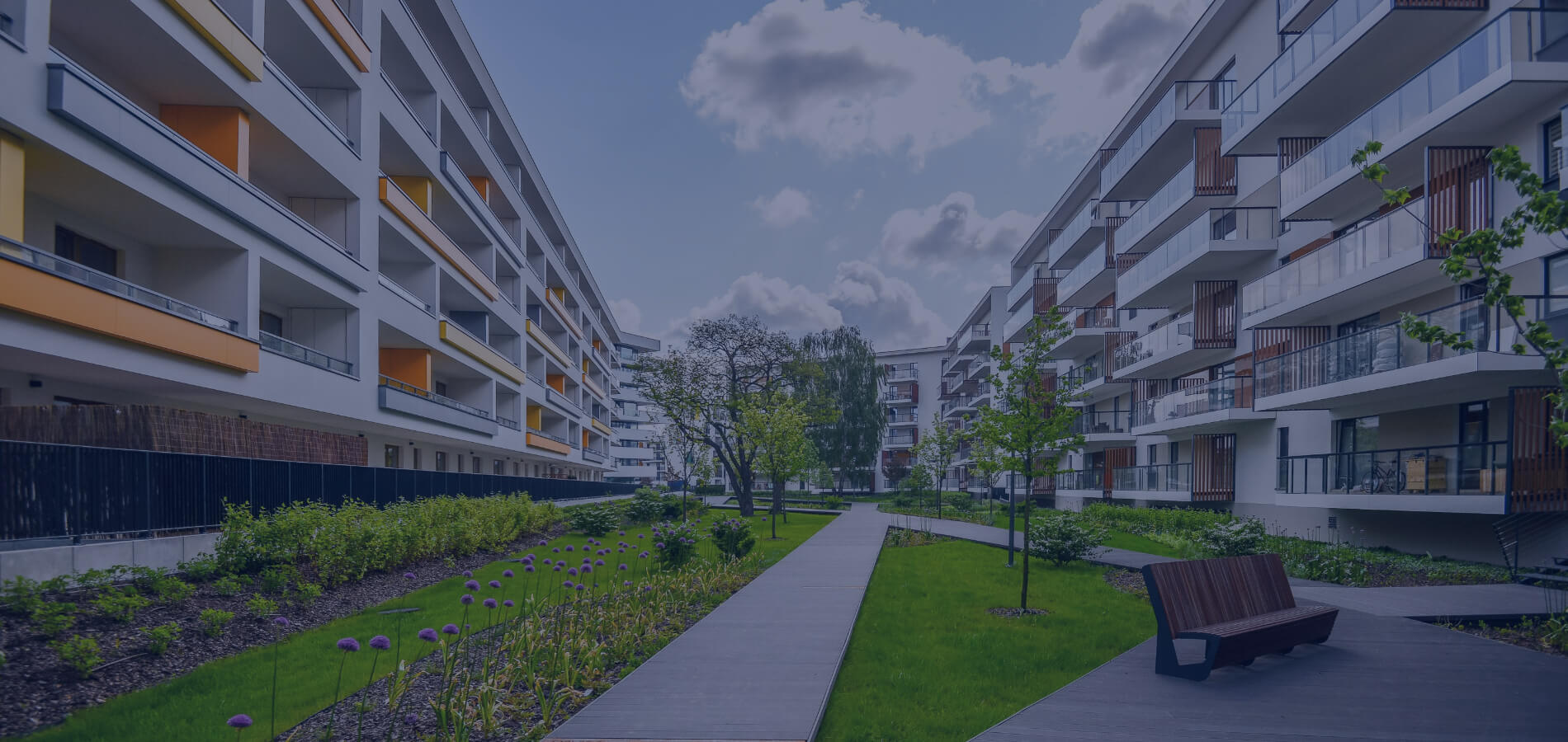 Zwei Fassadenreiniger in Schutzausrüstung hängen an Seilen und reinigen die Glasfassade eines Bürogebäudes.